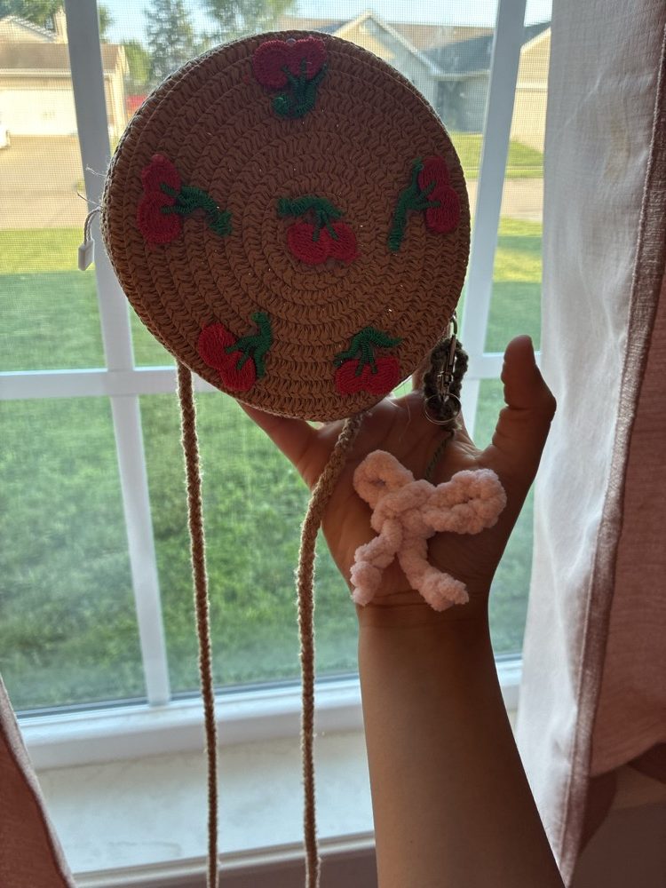 Straw bag with cherries and a pink crochet bow charm