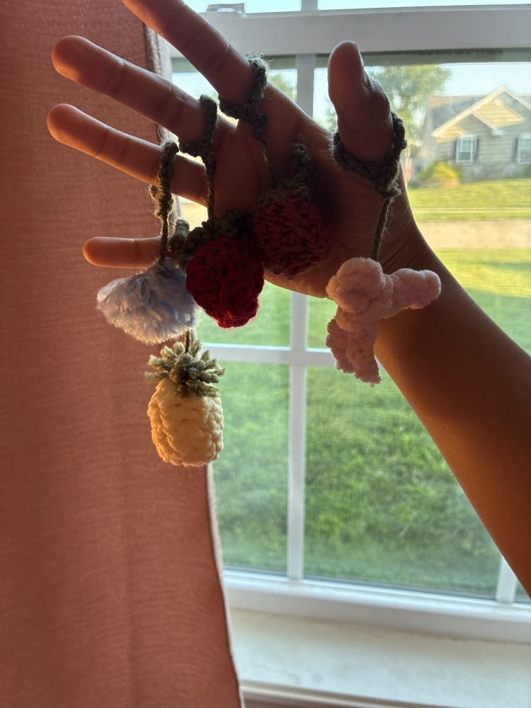 A handful of tiny crochet fruit charms — strawberry, pineapple, and more on clips